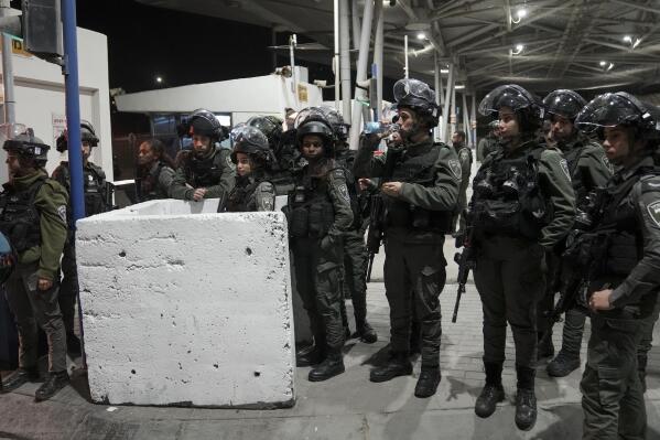 Israeli border police officers gather at the scene of an alleged stabbing attack at Shuafat crossing in east Jerusalem, Monday, Feb. 13, 2023. Israeli police said a Palestinian attacker pulled out a knife during an inspection at a military checkpoint, and officers opened fire. Police said the attacker was arrested and an officer was critically wounded in the incident. (AP Photo/Mahmoud Illean)