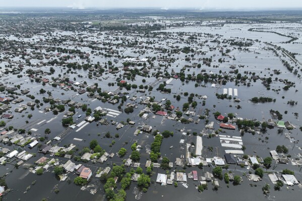 FILE - Houses are seen underwater in the flooded town of Oleshky, Ukraine, Saturday, June 10, 2023. Some Ukrainians living under Russian occupation are so desperate to escape that they take long, circuitous and uncertain journeys through Russia to return to Ukrainian-held territory. (AP Photo, File)