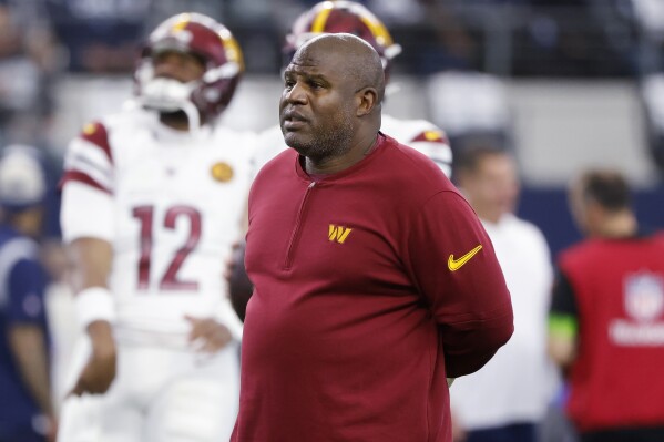 FILE -Washington Commanders offensive coordinator Eric Bieniemy watches players warm up for an NFL football game against the Dallas Cowboys, Nov. 23, 2023, in Arlington, Texas. Bieniemy is on the verge of returning home for his next job. The former Kansas City Chiefs and Commanders offensive coordinator is expected to become UCLA’s associate head coach and offensive coordinator, two persons familiar with the situation told The Associated Press. (AP Photo/Michael Ainsworth, File)