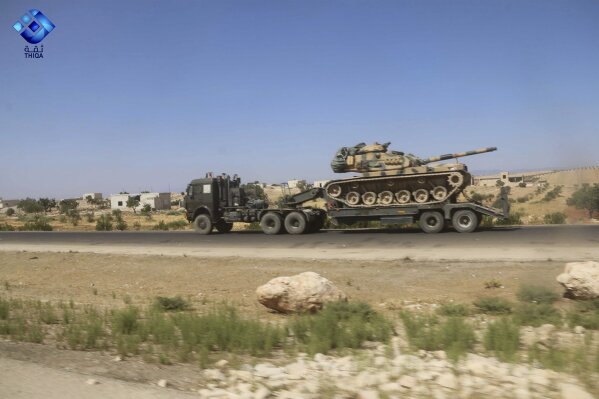 This photo provided by the activist-operated Thiqa News Agency, shows part of a Turkish military convoy heading toward the town of Khan Sheikhoun, a rebel-held northwestern town that's part of a government offensive on the country's last rebel stronghold, in Idlib province, Syria, Monday, Aug. 19, 2019. A Turkish military convoy carrying ammunition crossed into northern Syria Monday and moved south through rebel-held areas before it was stopped by airstrikes that struck near the highway where the convoy was moving, opposition activists said. (Thiqa News Agency via AP)