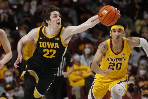 Iowa forward Patrick McCaffery (22) reaches for the ball as Minnesota guard Eylijah Stephens (20) pursues him in the second half of an NCAA college basketball game Sunday, Jan. 16, 2022, in Minneapolis. (AP Photo/Bruce Kluckhohn)