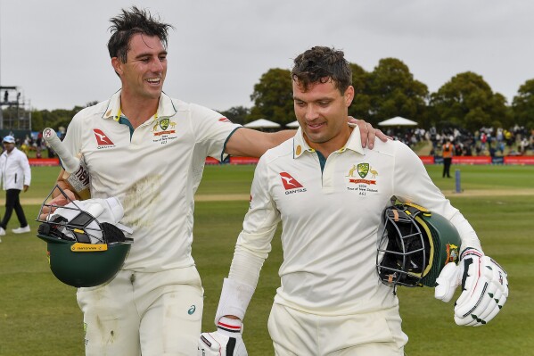 Australia's Alex Carey, right, and Pat Cummins walk from the field after defeating New Zealand by three wickets on day four of the second cricket test between New Zealand and Australia in Christchurch, New Zealand, Monday, March 11, 2024. (John Davidson/Photosport via AP)