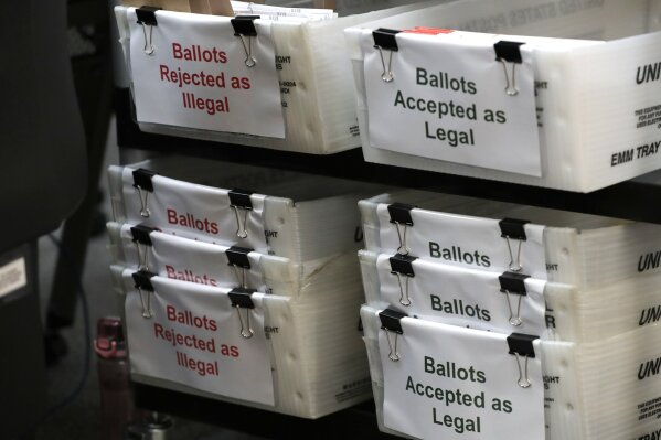 FILE - In this July 30, 2020, file photo, boxes for illegal and legal vote-by-mail ballots are shown as the the Miami-Dade County canvassing board meets to verify signatures on vote-by-mail ballots for the Aug. 18 primary election at the Miami-Dade County Elections Department in Doral, Fla. Never in U.S. history will so many people exercise the right on which their democracy hinges by marking a ballot at home. (AP Photo/Lynne Sladky, File)