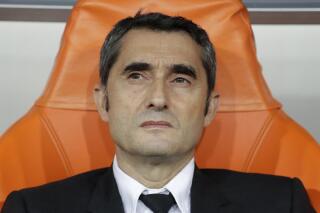 FILE - Barcelona's head coach Ernesto Valverde sits on the bench prior the Spanish Super Cup semifinal soccer match between Barcelona and Atletico Madrid at King Abdullah stadium in Jiddah, Saudi Arabia, on Jan. 9, 2020.  Bilbao's coach Ernesto Valverde is officially back as Athletic Bilbao’s coach. The Spanish club made the announcement five days after new president Jon Uriarte was elected and pledged to bring Valverde back for his third stint as the team’s coach. The 58-year-old Valverde has not coached since he was fired from Barcelona in January 2020. (AP Photo/Hassan Ammar)