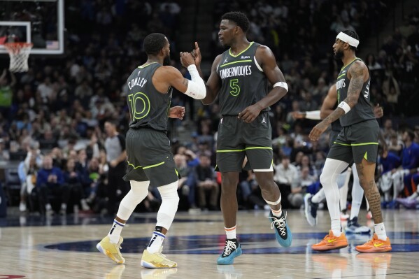 Minnesota Timberwolves guard Mike Conley (10), celebrates with guard Anthony Edwards (5) after making a three-point shot during the second half of an NBA basketball game against the New York Knicks, Monday, Nov. 20, 2023, in Minneapolis. (AP Photo/Abbie Parr)