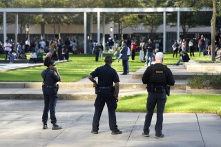 Houston Police officers watch over displaced churchgoers outside Lakewood Church, Sunday, Feb. 11, 2024, in Houston, after a reported shooting during a Spanish church service. Social media users are falsely claiming that the shooter has been identified as transgender. (Karen Warren/Houston Chronicle via AP)