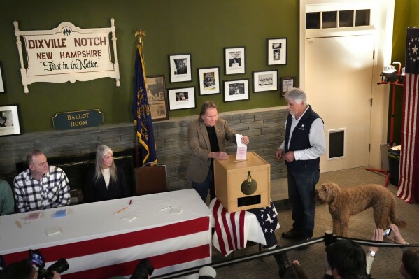 El moderador de la ciudad, Tom Tillotson, inserta su voto en las urnas de Les Otten, de extrema derecha, poco después de la medianoche en las elecciones primarias presidenciales, el martes 23 de enero de 2024, en Dixville Notch, NH. Los seis votantes seleccionaron a Nikki Haley.  (Foto AP/Robert F. Bukaty)