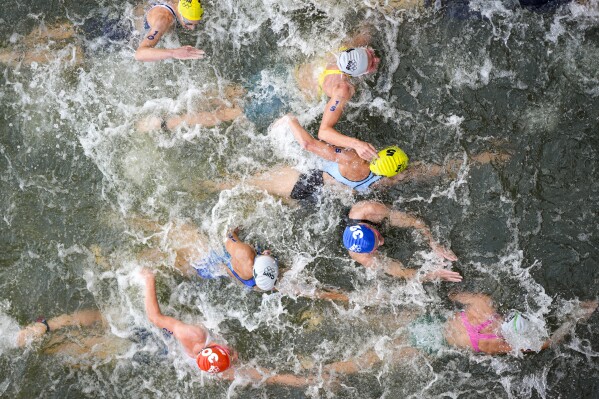 Australia's Natalie Van Coevorden (15), Belgium's Claire Michel (5) and Ekaterina Shabalina, of Kazakhstan (32) compete in the swim leg of the women's individual triathlon competition at the 2024 Summer Olympics, Wednesday, July 31, 2024, in Paris, France. (AP Photo/David Goldman)