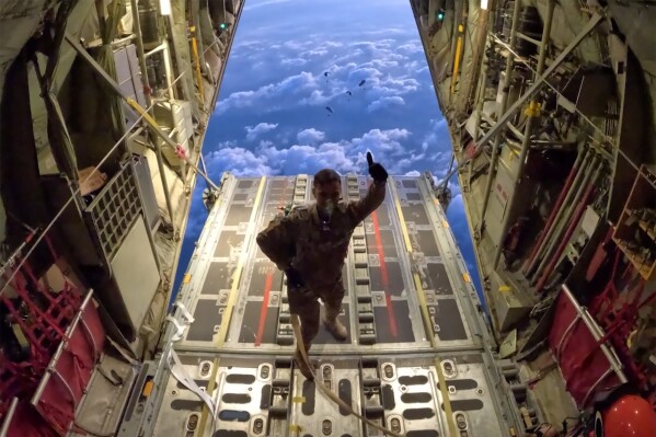 FILE - In this photo provided by the French Army, a soldier gestures before air-dropping some material over the Gaza Strip, on Jan. 4, 2024. A top European Union official is Cyprus on Friday, March 8, 2024, to inspect preparations for sending desperately needed aid to war-ravaged Gaza by sea, just hours after President Joe Biden announced that the U.S. military will set up a temporary port off Gaza's Mediterranean coast in support of such efforts. (Etat Major des Armees via AP)