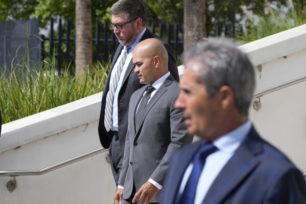Walt Nauta, center, valet to former president Donald Trump, his attorney Stanley Woodward, rear, and Carlos De Oliveira, foreground, the property manager of Trump's Mar-a-Lago estate, leave the Alto Lee Adams Sr. U.S. Courthouse, Thursday, Aug. 10, 2023, in Fort Pierce, Fla. Nauta pleaded not guilty for a second time to conspiring with the former president to obstruct the investigation into his possession of classified documents at his Florida estate. De Oliveira was again unable to enter a plea in the case on Thursday because he hasn't secured a Florida-based attorney. (AP Photo/Wilfredo Lee)