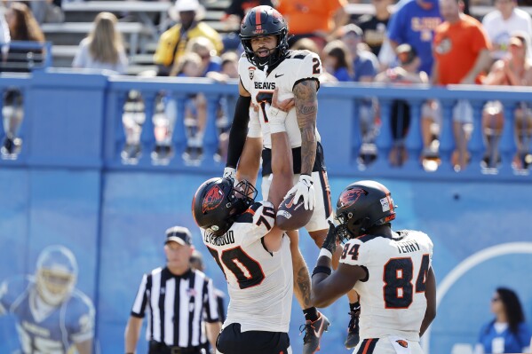 Oregon State offensive lineman Jake Levengood (70) lifts wide receiver Anthony Gould (2) who scored a touchdown in the second half of an NCAA college football game against San Jose State in San Jose, Calif., Sunday, Sept. 3, 2023. (AP Photo/Josie Lepe)