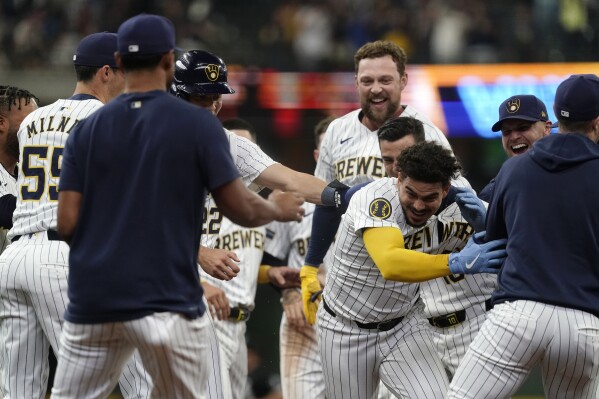 Milwaukee Brewers' Willy Adames, second from front right, is congratulated by teammates after hitting a walkoff RBI single during the 10th inning of a baseball game against the Chicago White Sox, Saturday, June 1, 2024, in Milwaukee. (AP Photo/Aaron Gash)