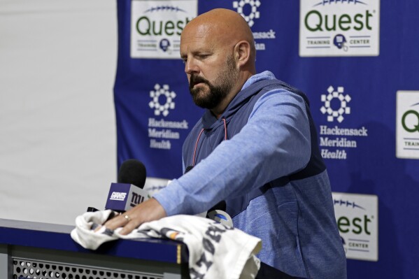 New York Giants head coach Brian Daboll wipes down the podium before speaking with the press before NFL football practice, Thursday, May 23, 2024, in East Rutherford, N.J. (AP Photo/Adam Hunger)