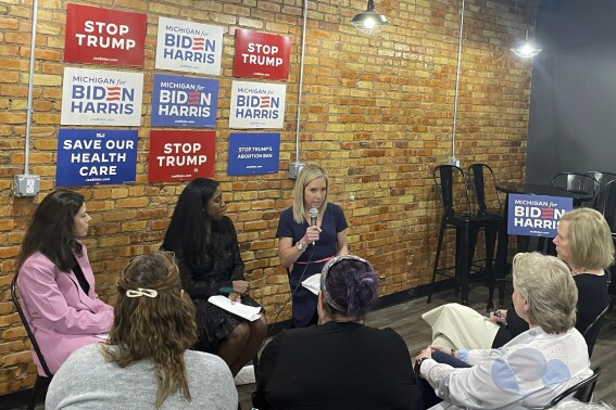 Amanda Zurawski, top center, speaks about how Texas abortion restrictions nearly cost her life during an event in Lansing, Mich, Tuesday, May 7, 2024. Zurawski and Kaitlyn Joshua, third from left, visited Michigan to campaign for President Joe Biden and highlight how women's health is being affected by the overturning of federal abortion protections. (AP Photo/Joey Cappelletti)