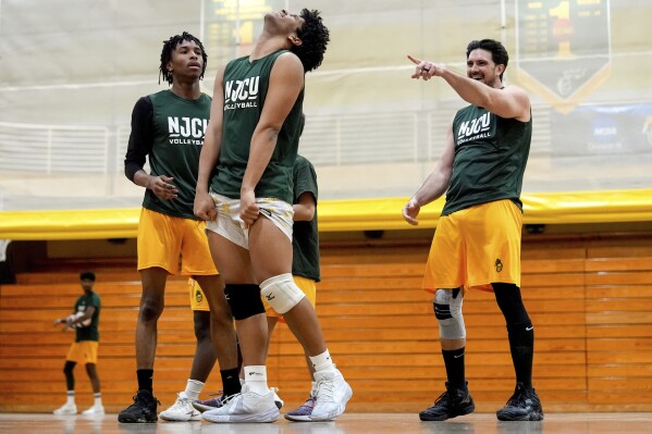 Damon LaSalle, right, jokes with teammates during volleyball practice, Friday, Feb. 21, 2025, at New Jersey City University in Jersey City, N.J. (AP Photo/Julia Demaree Nikhinson)