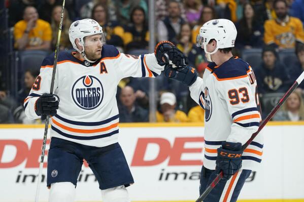 Edmonton Oilers' Leon Draisaitl (29) is congratulated by Ryan Nugent-Hopkins (93) after Draisaitl scored a goal against the Nashville Predators in the first period of an NHL hockey game Thursday, April 14, 2022, in Nashville, Tenn. (AP Photo/Mark Humphrey)