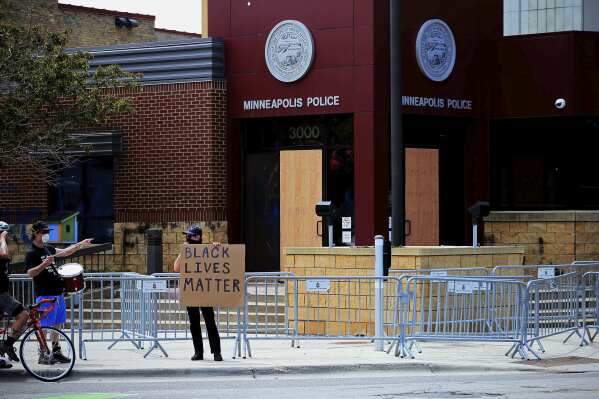 FILE - Doors are boarded up as protesters gather at the Minneapolis Police Third Precinct Wednesday, May 27, 2020, in Minneapolis, as people protest the arrest and death of George Floyd who died in police custody. The Minneapolis City Council and Mayor Jacob Frey agreed on Thursday, Nov. 2, 2023, on a new location for a police station to replace the one ransacked and set on fire in response to the murder of George Floyd by a city police officer. (AP Photo/Jim Mone, File)