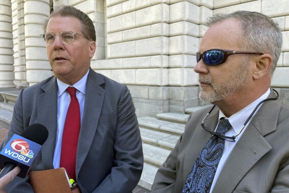 Lawyer Paul Sterbcow, left, with his client, attorney Richard Trahant, talks to reporters outside the federal appeals court building in New Orleans, Wednesday, April 3, 2024. Trahant is appealing a $400,000 court sanction for allegedly violating a bankruptcy court secrecy order by alerting a school principal and a reporter that a suspected child predator was working as a chaplain at a high school. (AP Photo/Kevin McGill)