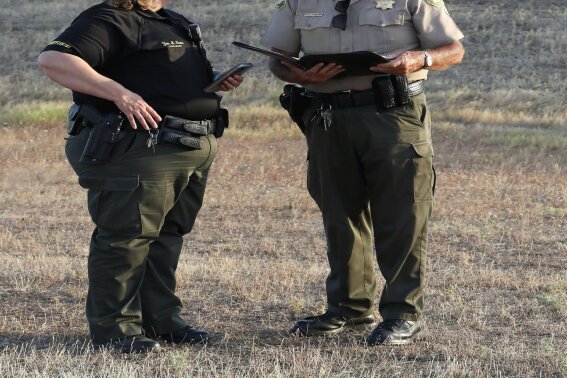 Lt. Yvette Borden and Assistant Sheriff Phil Johnston, of the Tehama County Sheriff's Office, talk before holding a news conference, Saturday, June 27, 2020, outside the Red Bluff Walmart Distribution Center where at least two people were killed, including the shooting suspect and an employee, and four were injured, in Red Bluff, Calif. (Mike Chapman/The Record Searchlight via AP)