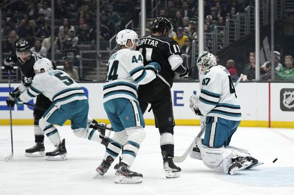 Los Angeles Kings center Quinton Byfield, left, scores on San Jose Sharks goaltender James Reimer, right, as defenseman Matt Benning, second from left, defenseman Marc-Edouard Vlasic, center, and center Anze Kopitar watch during the first period of an NHL hockey game Wednesday, Jan. 11, 2023, in Los Angeles. (AP Photo/Mark J. Terrill)
