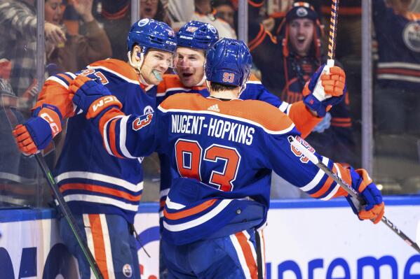 Edmonton Oilers' Warren Foegele (37), Ryan Nugent-Hopkins (93) and Zach Hyman (18) celebrate a goal against the Tampa Bay Lightning during the second period of an NHL hockey game Thursday, Jan. 19, 2023, in Edmonton, Alberta. (Jason Franson/The Canadian Press via AP)