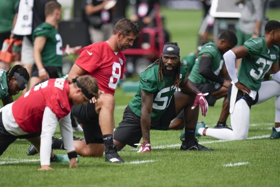 New York Jets quarterback Aaron Rodgers, second from left, talks with C.J. Mosley (57), center, during warm-ups at the NFL football team's training facility in Florham Park, N.J., Thursday, July 20, 2023. (AP Photo/Seth Wenig)