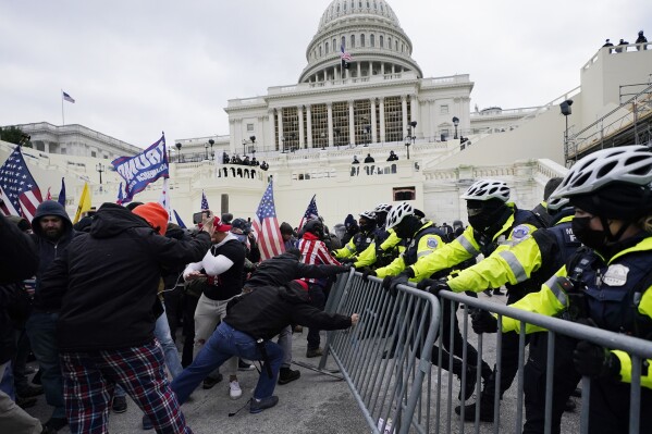 FILE - Violent insurrectionists loyal to then-President Donald Trump try to break through a police barrier, Wednesday, Jan. 6, 2021, at the Capitol in Washington. (Ǻ Photo/Julio Cortez, File)