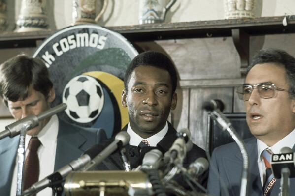 FILE - New York Cosmos' Pele stands with others at news conference in New York on June 10, 1975. Dozens of meetings over four years led to Pelé agreeing to sign with Cosmos in June 1975. His 2 1/2 seasons in New York elevated the sport, putting U.S. soccer on a path to hosting the World Cup in 1994 and launching Major League Soccer two years later. (AP Photo, File)