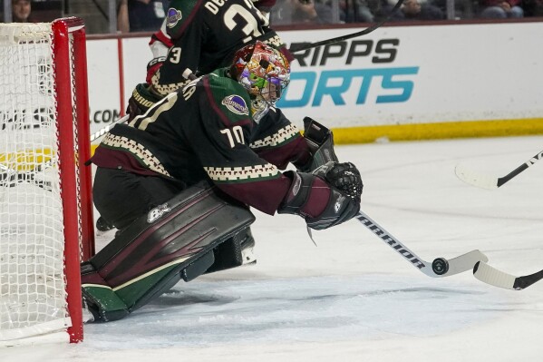Arizona Coyotes goaltender Karel Vejmelka (70) blocks a shot against the New Jersey Devils during the second period of an NHL hockey game, Saturday, March 16, 2024, in Tempe, Ariz. (AP Photo/Darryl Webb)
