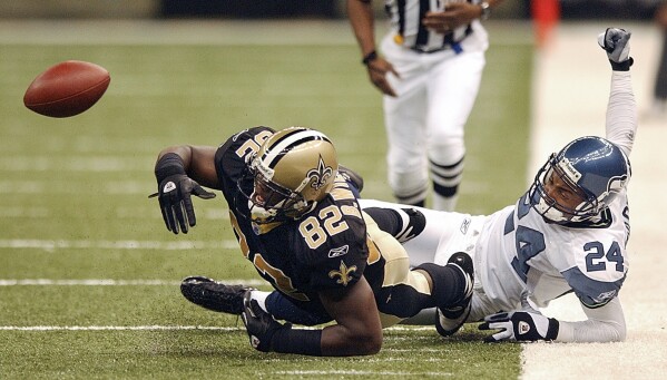 FILE - Seattle Seahawks' cornerback Bobby Taylor (24), right, watches the result of his knocking the ball loose from New Orleans Saints tight end Boo Williams (82) during the first half at the Superdome Sept. 12, 2004, in New Orleans, La. Williams needs surgery, medicine and doctors to make the pain subside from injuries he endured during his football career. But he can't afford any of it. The 44-year-old was recently awarded $5,000 a month by the NFL's disability benefit plan. But Williams said the plan and the league have repeatedly mishandled his claims and should really have paid him $500,000 or more over the past 14 years. (AP Photo/Sun Herald, David Purdy, File)