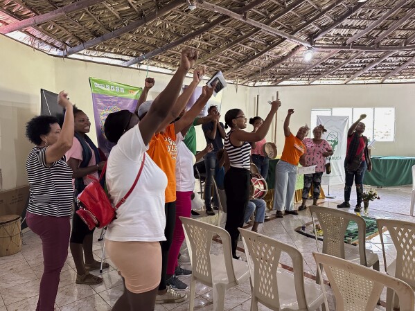 Members of the National Confederation of Rural Women (CONAMUCA) sing during a visit from U.S. legislators and members of Women’s Equality Center at the organization’s headquarters in San Cristobal, Dominican Republic, Friday, Dec.8, 2023. The Women's Equality Center set up a visit for U.S. legislators to visit the D.R. to see first hand the effects of the nation's total abortion ban. (AP Photo/Maria Hernandez)