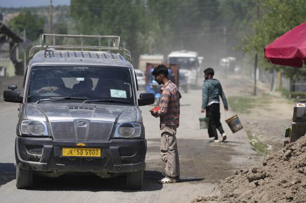 A Kashmiri man sells cherry to passersby and travelers on the Srinagar-Muzaffarabad highway, after India and Pakistan reported no incidents of firing overnight, in Pattan in Indian controlled Kashmir Monday, May 12, 2025. (AP Photo/Mukhtar Khan)