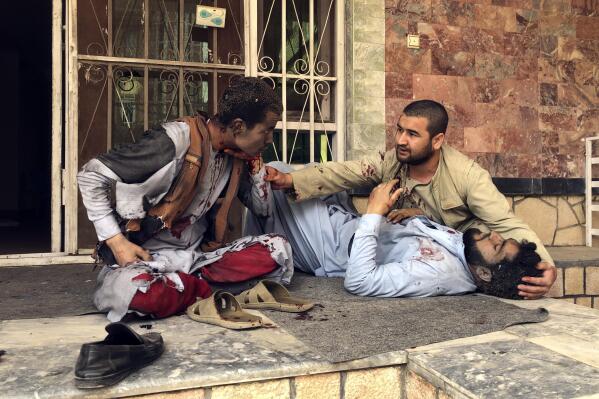 An injured man lies down after a bomb blast in Mazar-e-Sharif, the capital city of Balkh province, in northern Afghanistan, Saturday, March 11, 2023. A bomb exploded on Saturday during an award ceremony for journalists in the city. (AP Photo/Abdul Saboor Sirat)