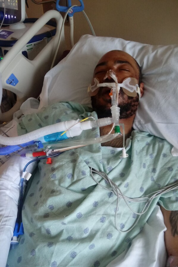 This photo provided by Rita Gowens shows her son, Demetrio Jackson, at the Sacred Heart Hospital in Eau Claire, Wis., in October 2021. Gowens spoke to him, held his hand and hoped for a miracle. She eventually agreed to remove him from a ventilator after his condition didn’t improve, singing into his ear as he took his final breaths: “You’ve never lost a battle, and I know, I know, you never will.” (Rita Gowens via AP)