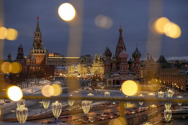 The Spasskaya Tower, Red Square, the GUM department store and the St. Basil's Cathedral are decorated for the New Year and Christmas festivities are seen though a window of the Hotel Baltschug Kempinski Moscow in Moscow, Russia, on Tuesday, Dec. 26, 2023. (AP Photo/Alexander Zemlianichenko)