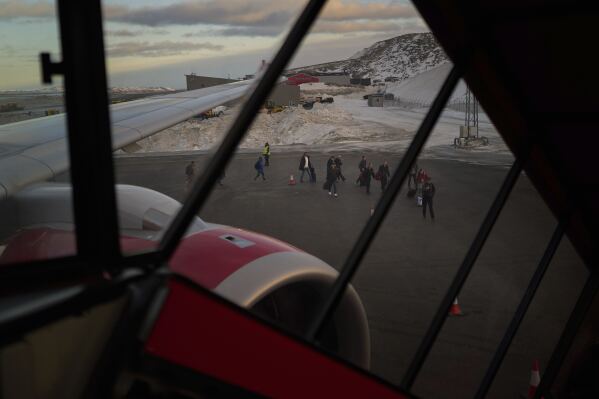 People disembark from a plane as they arrive at the International airport in Nuuk, Greenland, Friday, Feb. 14, 2025. (AP Photo/Emilio Morenatti)