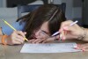 Giada Gambino, 10, left, becomes frustrated with a problem on a math worksheet from school as her mother helps her work through it at the dining room table in their home Wednesday, Aug.  23, 2023, in Spring, Texas.  (AP Photo/Michael Wyke)