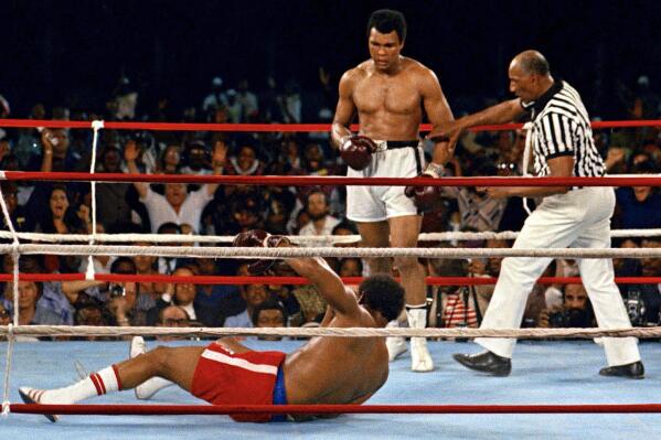 FILE - Referee Zack Clayton, right, steps in after challenger Muhammad Ali, second from right, knocked down defending heavyweight champion George Foreman, bottom, in the eighth round of their championship bout on Oct. 30, 1974, in Kinshasa, Zaire. Ali’s championship belt from the 1974 “Rumble in the Jungle” heavyweight title fight was sold at auction on Sunday, July 24, 2022, for $6.18 million. (AP Photo/File)