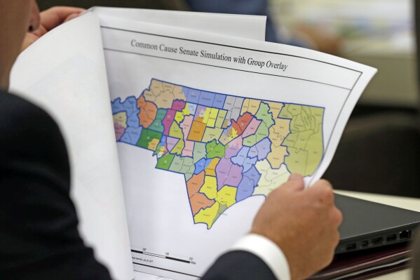 FILE - A North Carolina lawmaker studies a district map during a joint select committee meeting on redistricting, July 26, 2017, in Raleigh, N.C. North Carolina legislators are once again mapping the state’s congressional and General Assembly districts. The House and Senate redistricting committees scheduled hearings this week — the last one happening Wednesday, Sept. 27, 2023, in Raleigh — to receive public comment about the process of drawing district boundaries that would be used in the 2024 elections and for the remainder of the decade. (AP Photo/Gerry Broome, File)