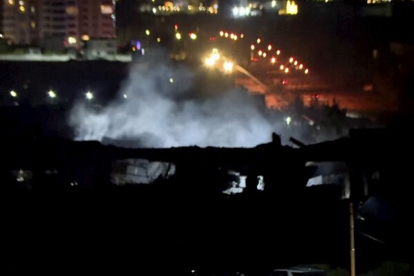 This image taken from video provided by Rudaw TV shows smoke rising from a building hit by a strike in Irbil, Iraq, Tuesday, Jan. 16, 2024. Iran has announced that it launched strikes against a “spy headquarters and the gathering of anti-Iranian terrorist groups” shortly after missiles hit an area near the U.S. consulate in Irbil, the seat of Iraq’s semi-autonomous Kurdish region. (Rudaw TV via AP)