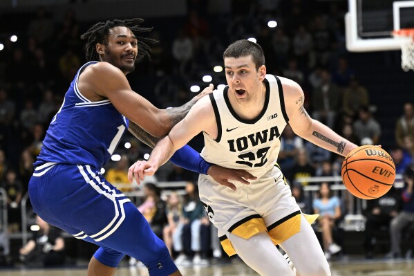 Iowa forward Patrick McCaffery (22) drives past Seton Hall guard Dre Davis during the first half of an NCAA college basketball game Friday, Nov. 24, 2023, in San Diego. (AP Photo/Denis Poroy)