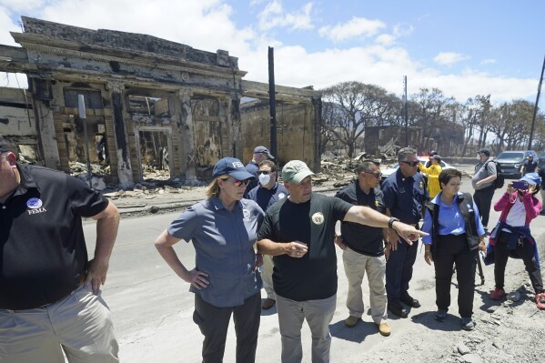FILE - Hawaii Gov. Josh Green, center, points to damage as he speaks with Federal Emergency Management Agency Administrator Deanne Criswell during a tour of wildfire damage, Saturday, Aug. 12, 2023, in Lahaina, Hawaii. On Friday, Aug. 18, FEMA said it approved $2.3 million in assistance to roughly 1,300 households in Maui so far, as the federal government tries to help survivors of the devastating wildfires. (AP Photo/Rick Bowmer, File)