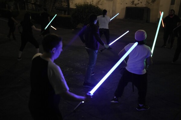 Students of the Jedi Knight Academy learn how to use lightsabers at a park in Mexico City, late Thursday, June 20, 2024. The academy is a lightsaber combat and choreography school founded in 2019 and a dream come true for fans of Star Wars. (AP Photo/Eduardo Verdugo)