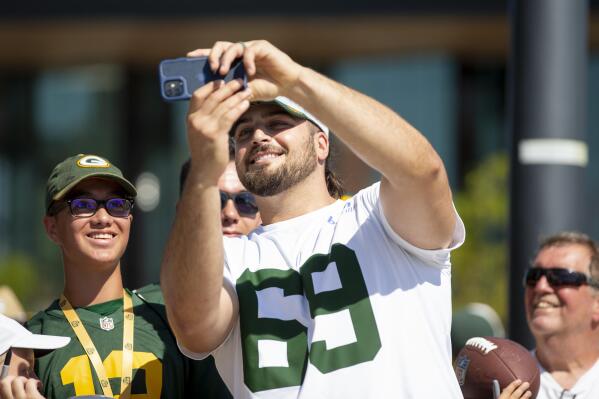 Green Bay Packers tackle David Bakhtiari (69) takes a selfie with a fan before NFL football training camp on Wednesday, Aug. 10, 2022, at Ray Nitschke Field in Ashwaubenon, Wis. (Samantha Madar/The Post-Crescent via AP)