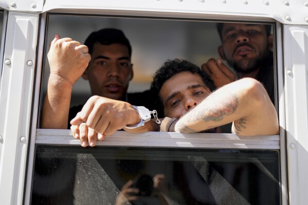 Colombian migrants look from a panamic immigration bus that transported her from a migrant reception center in Laja's Blancas, where they arrived on the way to the southern border of the USA in Panama City on March 11, 2025. (AP Photo/Matias Delacroix).