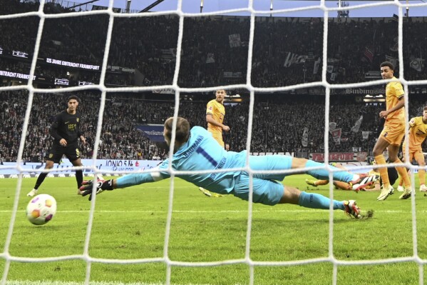 Frankfurt's Robin Koch, not pictured, scores the equalizer for 1:1 against Hoffenheim's goalkeeper Oliver Baumann during the German Bundesliga soccer match between TSG Hoffenheim and Eintracht Frankfurt at Deutsche Bank Park in Frankfurt, Germany, Sunday March 10, 2024. (Arne Dedert/dpa via AP)