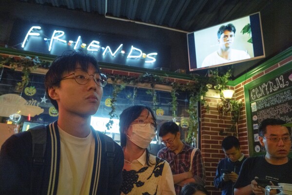 Fans of the hit sit-com "Friends" gather at a cafe that pays homage to the Central Perk cafe in the series to commemorate the death of Matthew Perry who played the Chandler Bing character, in Shanghai, Wednesday, Nov. 1, 2023. Long before "Friends" made its official debut in China, the show was a word-of-mouth phenomenon in the country. In the wake of Matthew Perry's death at 54, fans in China are mourning the loss of the star who felt less like a distant celebrity and more like an old friend. (AP Photo/Ng Han Guan)