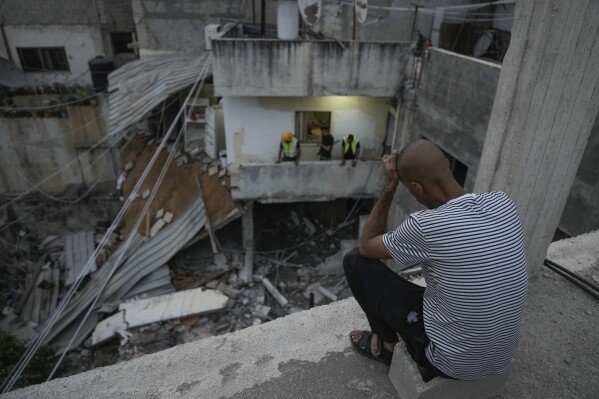 Palestinos inspeccionan un edificio dañado tras una redada del ejército israelí en el campo de refugiados de Nour Shams, en el norte de Cisjordania, el 24 de septiembre de 2023. Al menos dos personas murieron en la incursión, que según el ejército pretendía destruir un centro de mando miliciano y un almacén de bombas en el edificio. (AP Foto/Majdi Mohammed)