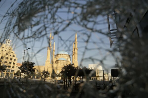 Mohammad Al-Amin Mosque is seen through a broken glass door of a shop after a protest against the Lebanese government in Beirut, Lebanon, Saturday, Oct. 19, 2019. The blaze of protests was unleashed a day earlier when the government announced a slate of new proposed taxes, including a $6 monthly fee for using Whatsapp voice calls. The measures set a spark to long-smoldering anger against top leaders from the president and prime minister to the numerous factional figures many blame for decades of corruption and mismanagement. (AP Photo/Hassan Ammar)