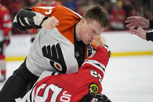 Philadelphia Flyers defenseman Nick Seeler, top, punches Chicago Blackhawks center Reese Johnson during the third period of an NHL hockey game Wednesday, Feb. 21, 2024, in Chicago. The Flyers won 3-1. (APPhoto/Erin Hooley)